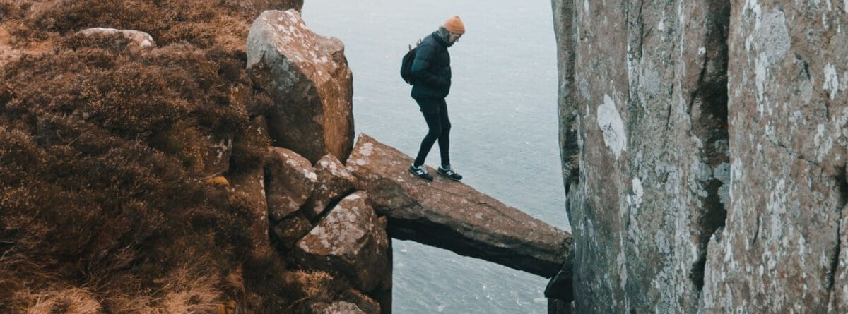 Eine Person balanciert auf einem felsigen Abgrund